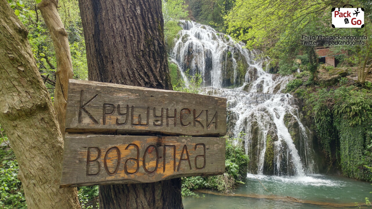 a sign showing Krushuna waterfalls and the waterfall in the back