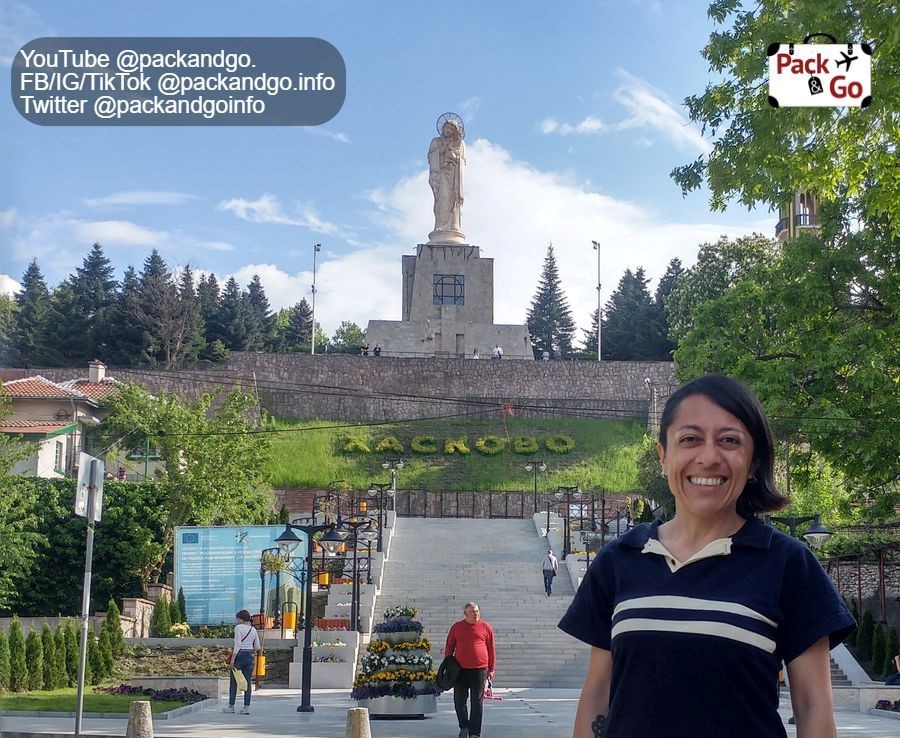 Girl in front, monument of Holy Mother of God in Haskovo Bulgaria