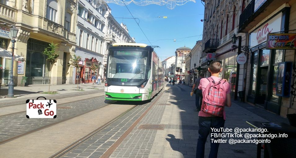 Man walking, tram passing, Miskolc, Hungary
